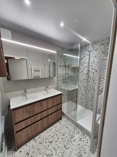 Salle de bains moderne avec meuble double vasque et douche en verre. Sol en mosaïque.